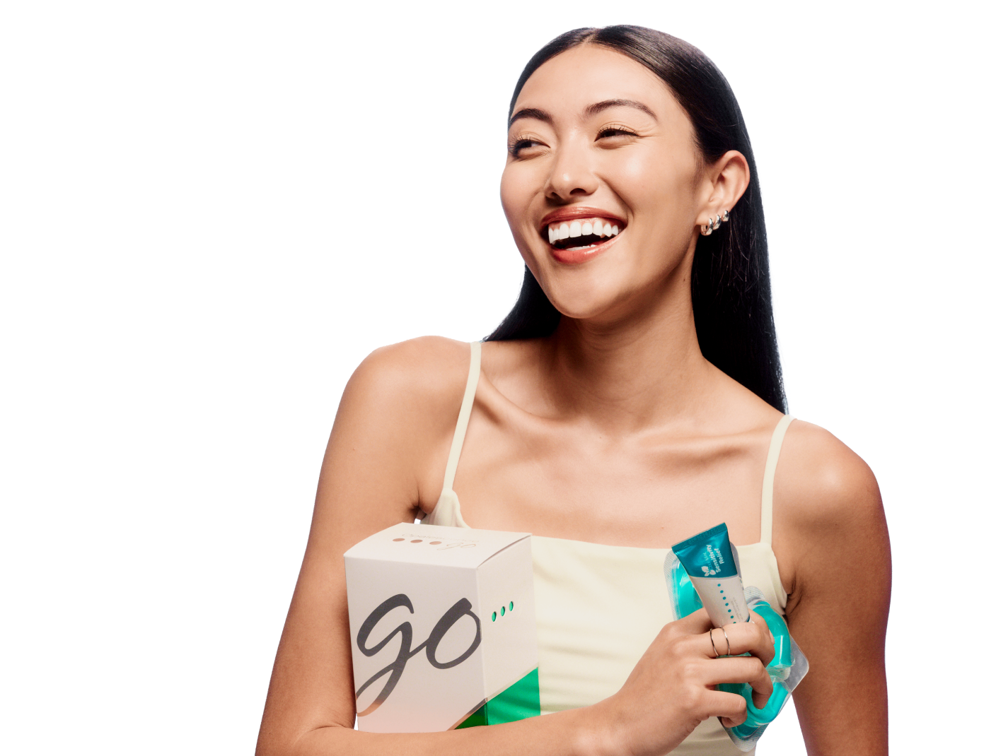 Smiling girl holding Opalescence products that come in the Starter Teeth Whitening kit including toothpaste and prefilled whitening trays