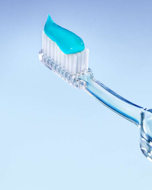 A clear toothbrush holding blue Opalescence toothpaste