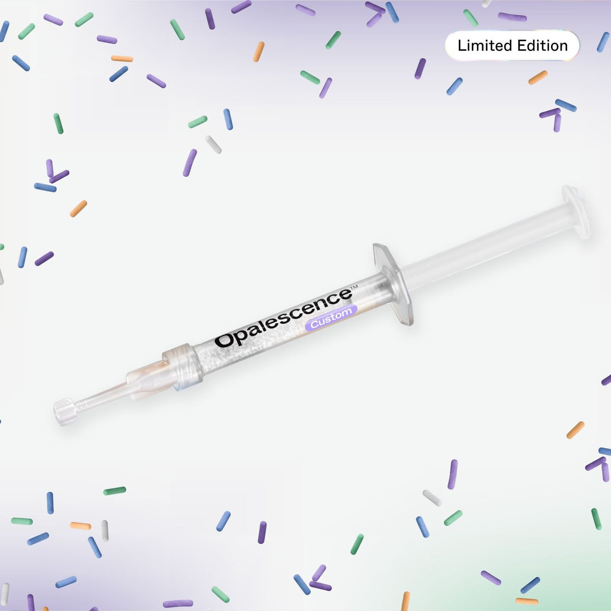 A single Opalescence Custom dental syringe shown diagonally on a white background with scattered pastel pill-shaped confetti and a 'Limited Edition' label in the top right.