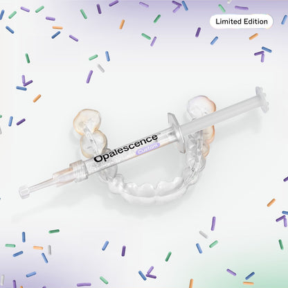 A clear dental impression tray with a syringe-style applicator labeled Opalescence Custom, shown on a white background with scattered multicolored sprinkle graphics and a 'Limited Edition' badge.