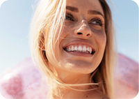 Woman with a bright smile against a light blue sky