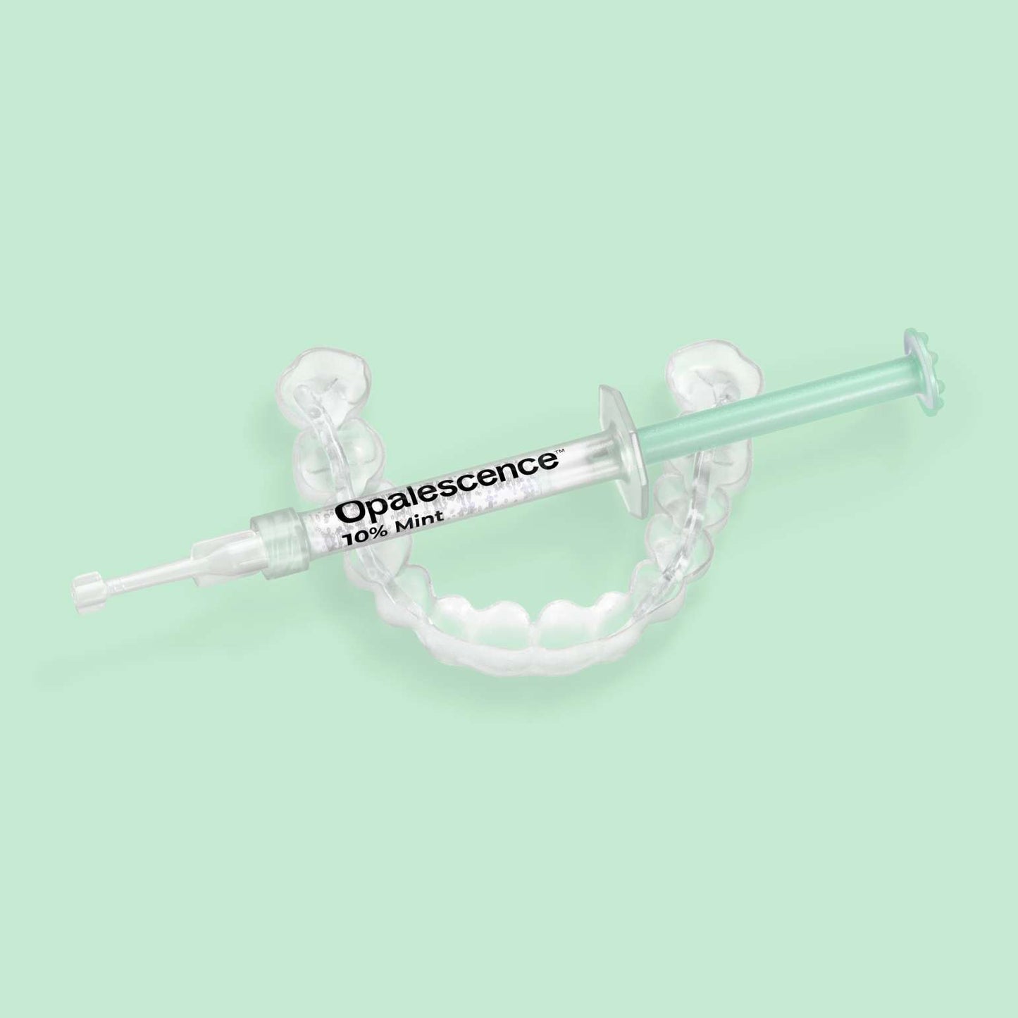 Opalescence 10% Mint syringe resting on a custom teeth whitening tray