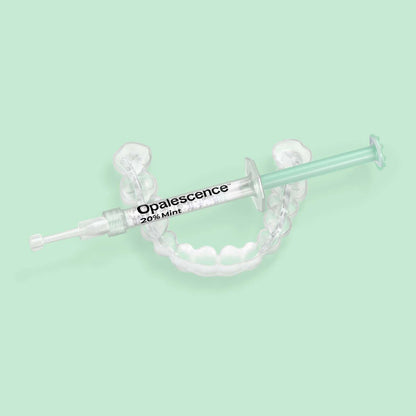 Opalescence 20% Mint syringe resting on a custom teeth whitening tray