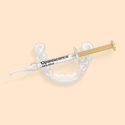 Opalescence 45% Mint syringe resting on a custom teeth whitening tray